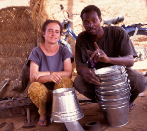 Tin-smiiths ||| Janet with the pails she made with Drissa's instruction. It took Janet a week to make 8 pails.
